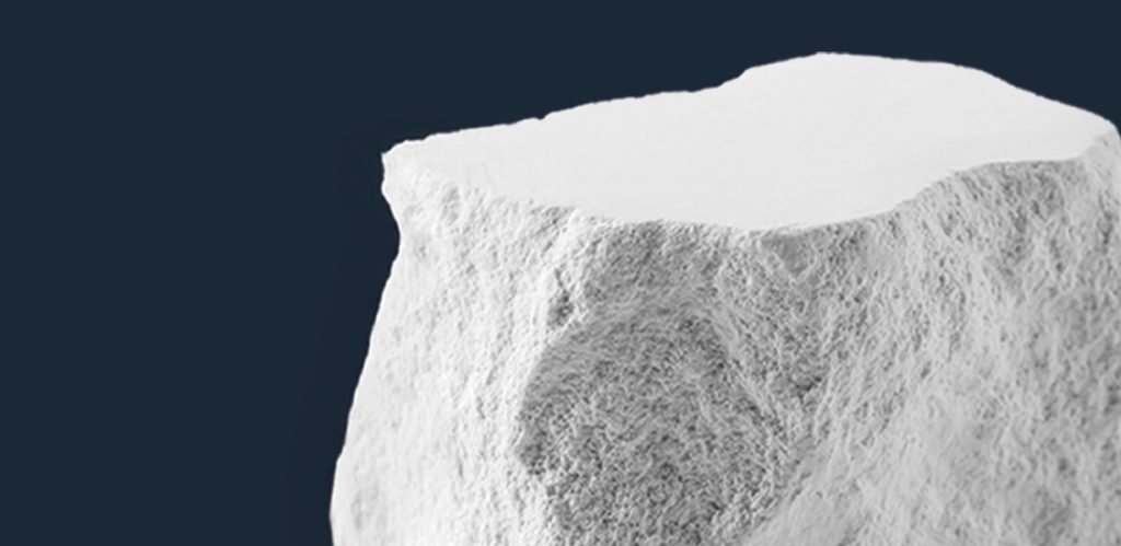 fragmento de bloque de piedra caliza cuadrangular sobre fondo azul oscuro